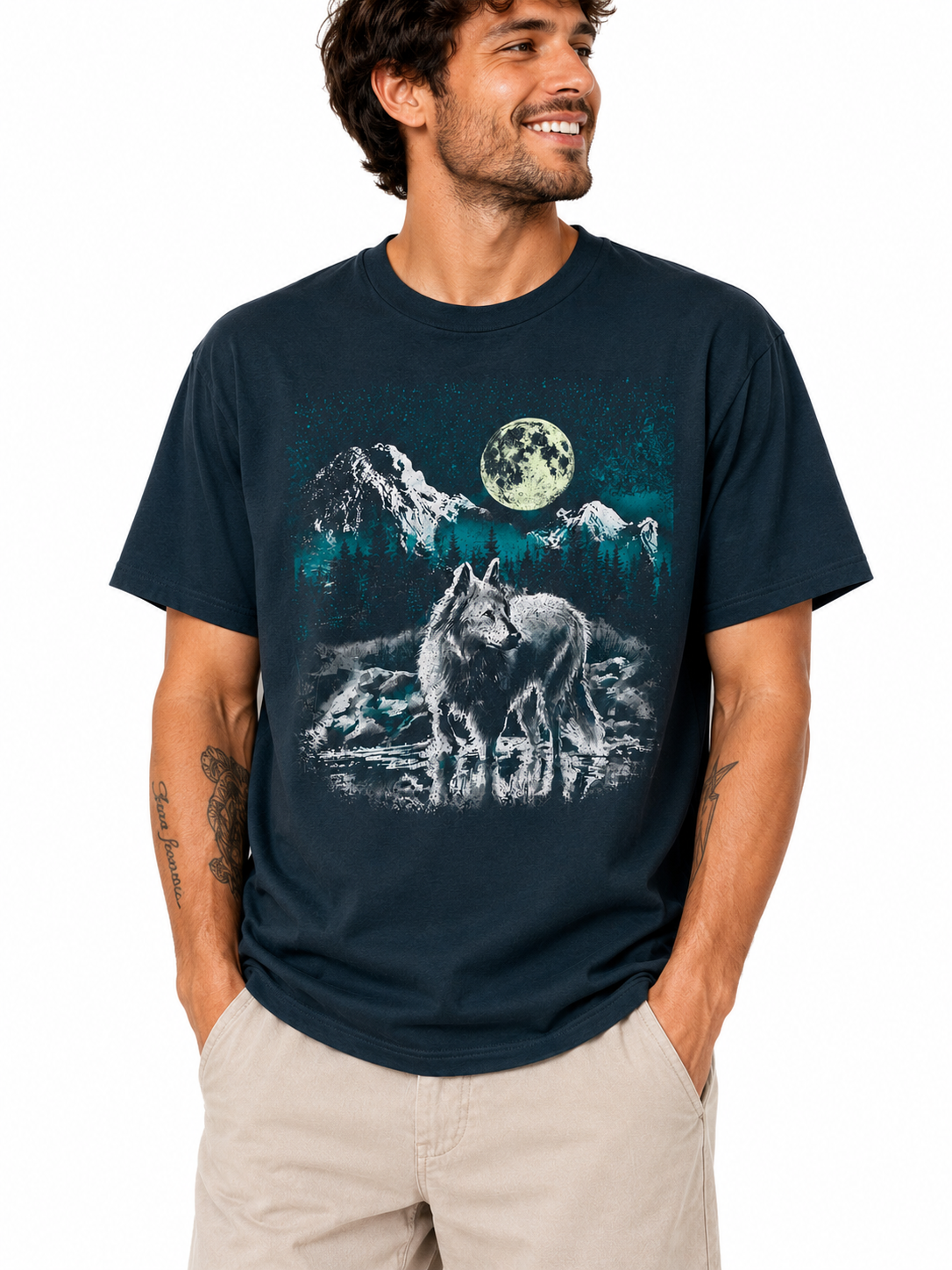 A man wearing a navy blue t-shirt with a graphic print of a wolf, mountains, and a full moon, paired with khaki shorts, against a plain white background.