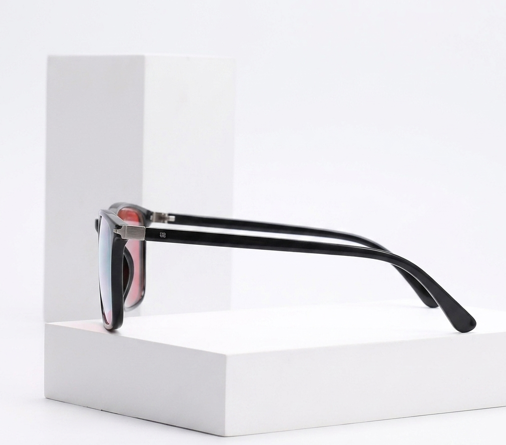 A pair of black-framed sunglasses with mirrored lenses resting on a white display block against a clean white background.