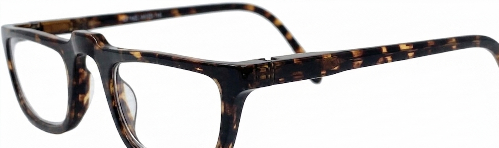 Close-up of a pair of eyeglasses with a dark tortoiseshell frame, featuring a dark brown and black mottled pattern with warm amber-brown spots, on a plain white background.
