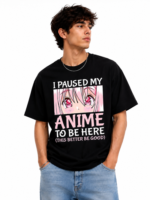 A man wearing a black graphic t-shirt with anime text and a pink-haired character print, paired with light blue jeans, against a plain white background.