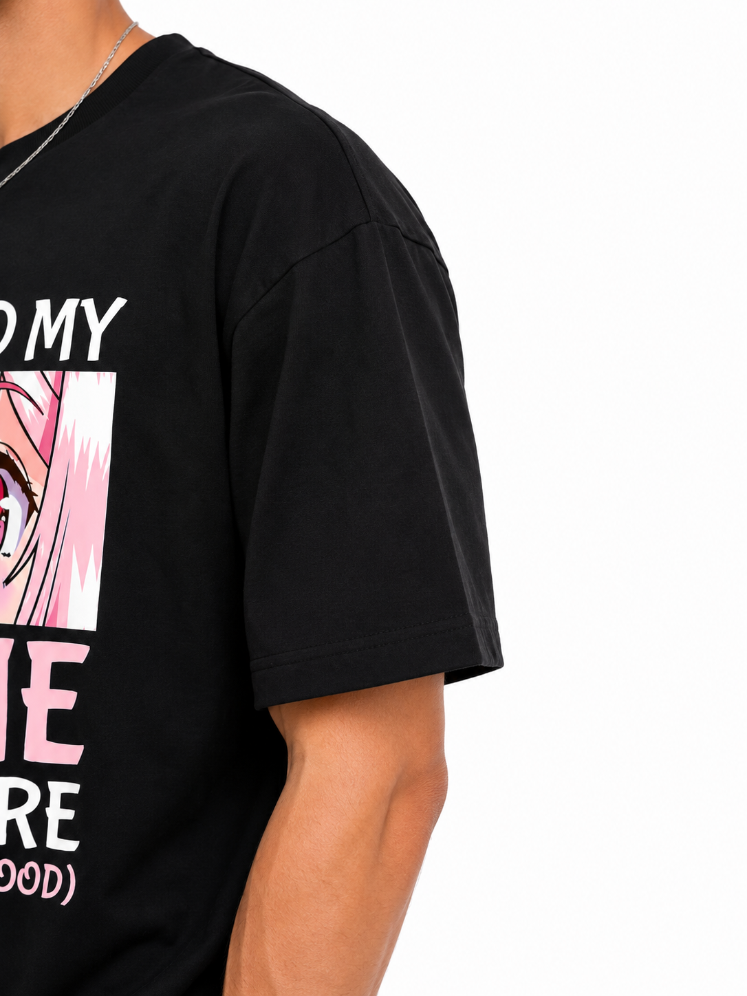 A close-up of a person wearing a black graphic T-shirt with a pink and white anime-style character print and partial white and pink text on the chest, against a plain white background.