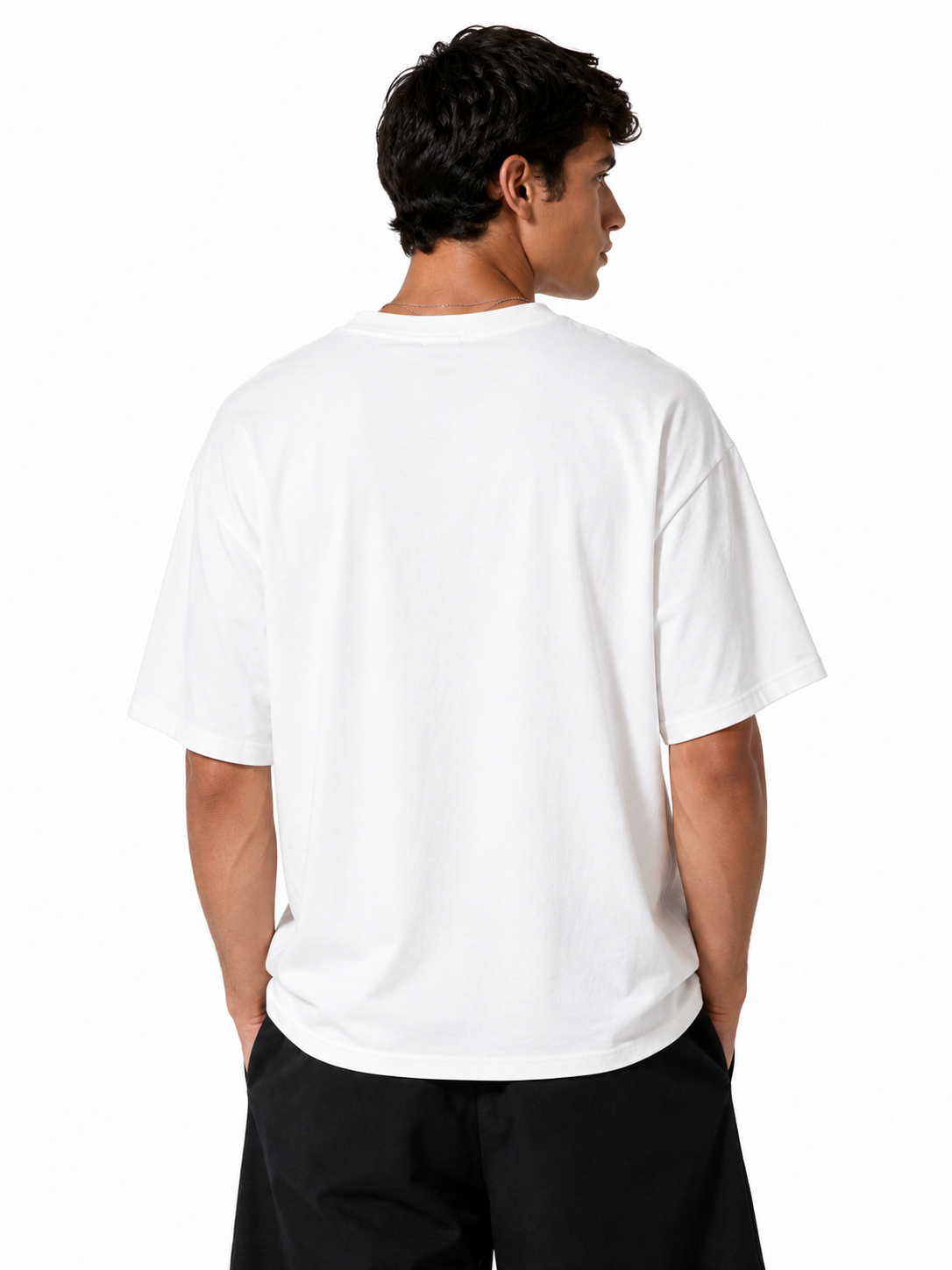 A man viewed from the back wearing a plain white short-sleeve crewneck t-shirt and black pants, set against a solid white studio background.