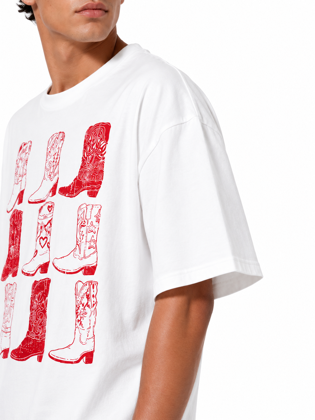 A close-up of a person wearing a white short-sleeve T-shirt with a red graphic print of cowboy boots on the front, against a plain white background.