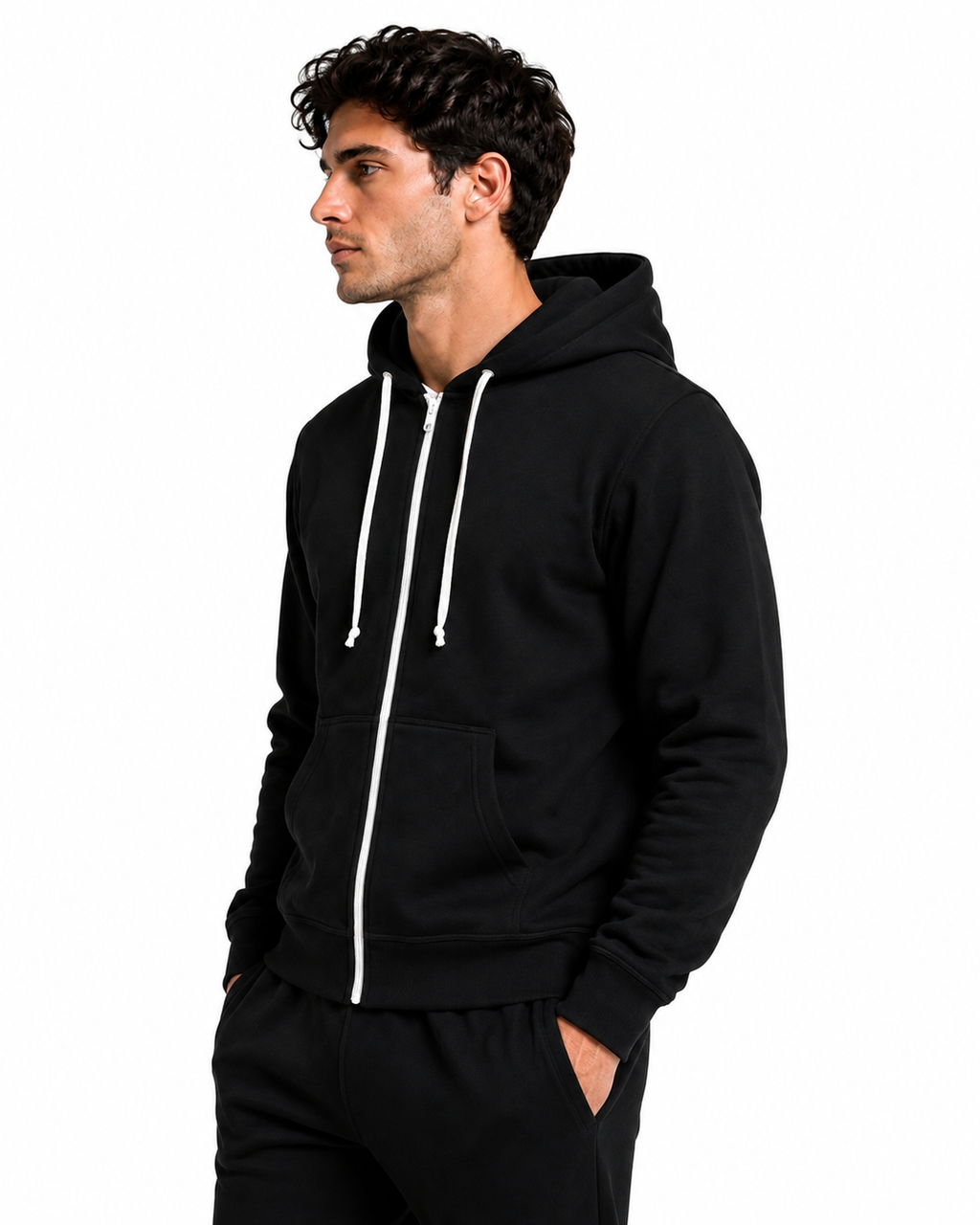 A man wearing a black zip-up hoodie with white drawstrings and white zipper trim, paired with black sweatpants, shown in profile against a plain white background.
